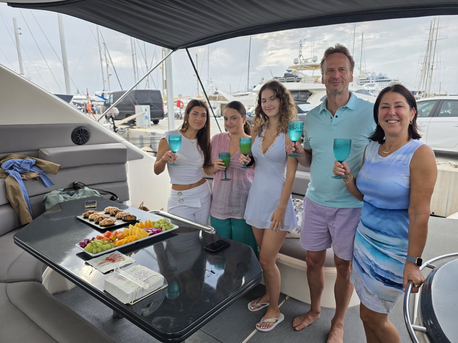 Invitados sonriendo con sus copas junto a los aperitivos de bienvenida