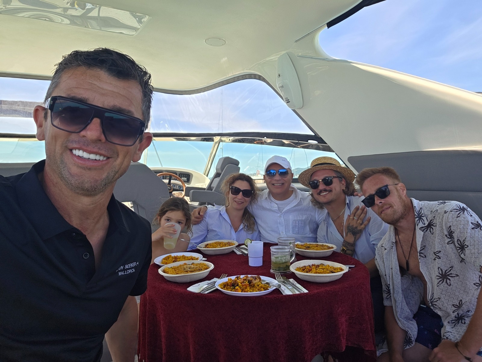 Un grupo sonriente compartiendo una comida a bordo del FUN SEEKER