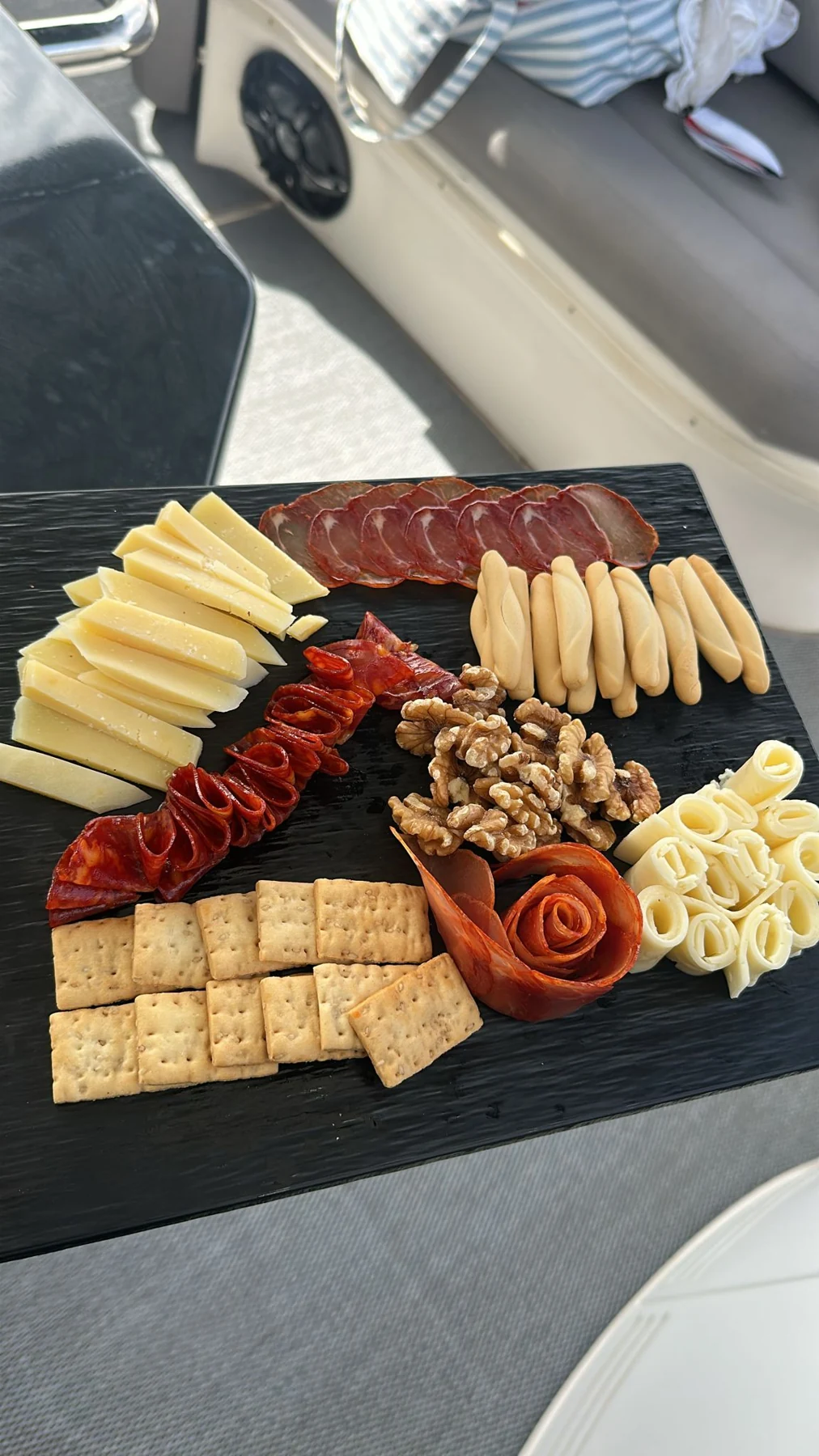 Tabla de quesos, embutidos, nueces y aperitivos preparada a bordo
